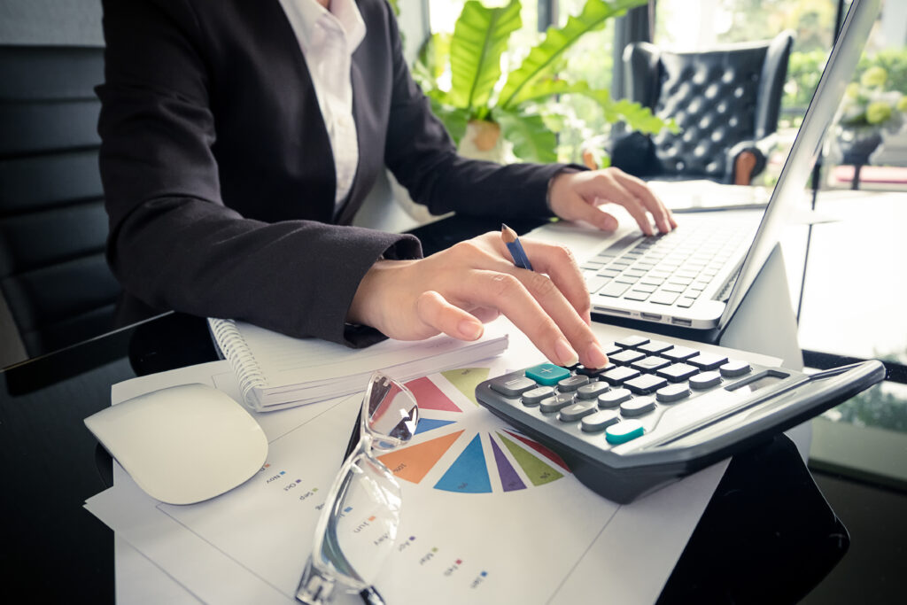 Business,Woman,Using,A,Calculator,To,Calculate,The,Numbers,On